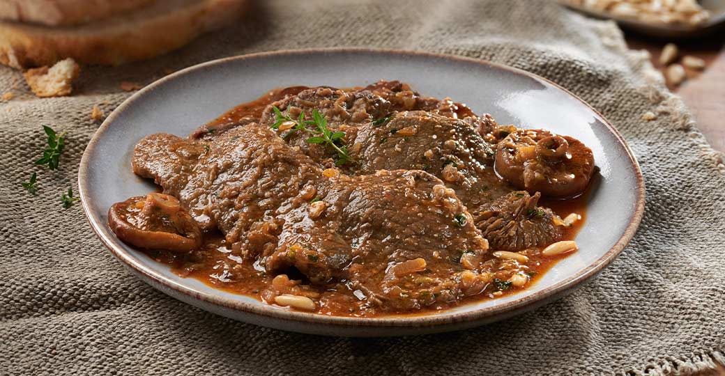 Plat de fricandeau de veau aux champignons et en sauce, typique de la gastronomie catalane d'automne.